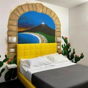 a bed in a room with a painting on the wall at Etna Suite Group in Catania