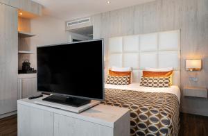a bedroom with a large flat screen tv on a bed at Van der Valk Hotel Oostzaan - Amsterdam in Oostzaan +36 photos
