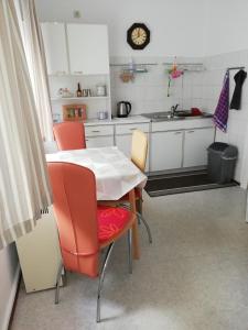 a kitchen with a table and chairs and a sink at Pension Becker Luckenwalde in Luckenwalde