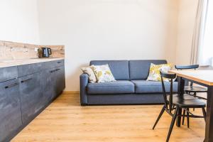 a living room with a blue couch and a table at Chiemseer Wirtshaus in Chieming