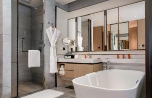 a bathroom with a tub and a sink and a shower at Crowne Plaza Shenzhen Nanshan, an IHG Hotel in Shenzhen