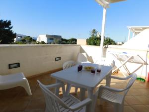 a white table and chairs on a balcony at Case Vacanza Elisir in Favignana