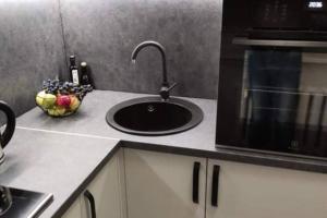 a kitchen counter with a sink and a microwave at Butas miesto centre/ Apartment in the city center in Šiauliai