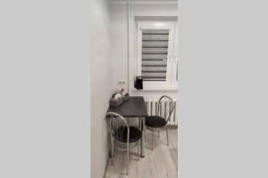 ein Esszimmer mit einem Tisch, Stühlen und einem Fenster in der Unterkunft Butas miesto centre/ Apartment in the city center in Šiauliai