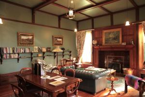 een woonkamer met een bank, een tafel en een open haard bij Buxton Manor in Adelaide
