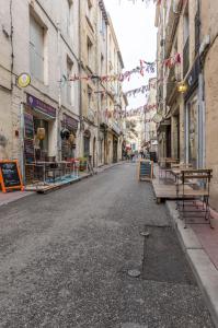 eine leere Stadtstraße mit Gebäuden und Flaggen in der Unterkunft La Parenthèse Roucher Montpellier - Duplex Climatisé T2 Cœur écusson in Montpellier