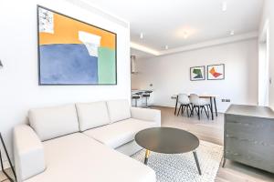 a living room with a white couch and a table at The Eight Apartments Shoreditch in London