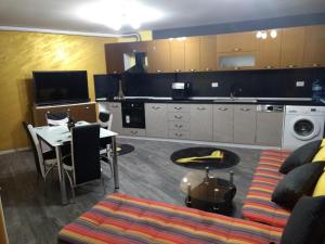 Una sala de estar con un sofá y una mesa y una cocina. en Valentina GOLD apartment, en Plovdiv