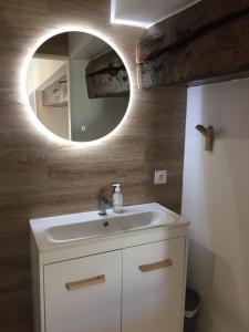 a bathroom with a white sink and a mirror at La Maison BellecOur in Vaudelnay