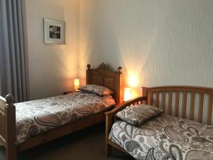 two twin beds in a bedroom with two lamps at The Wheatsheaf in Salisbury
