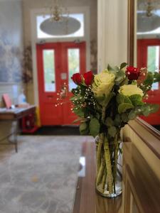 a vase filled with roses sitting on a table at Blue Bells Hotel in London