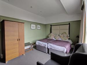 a bedroom with a bed, chair, and desk at Blue Bells Hotel in London