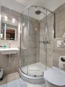 a bathroom with a shower and a toilet and a sink at Blue Bells Hotel in London