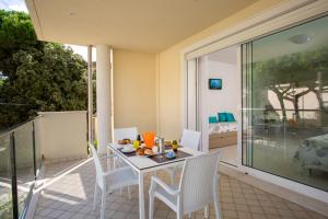 a dining room table with chairs and a patio at Residence I Diamanti in Cervia