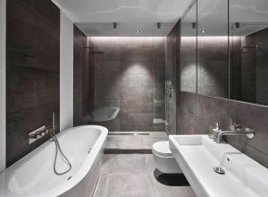 a bathroom with a tub and a toilet and a sink at The Eight Apartments Shoreditch in London