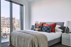 ein Schlafzimmer mit einem Bett mit Kissen und einem Fenster in der Unterkunft The Eight Apartments Shoreditch in London