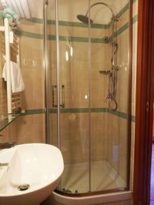 um chuveiro com uma porta de vidro ao lado de um lavatório em Locanda San Cosimato em Roma