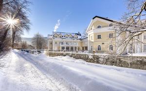śnieżna droga przed dużym domem w obiekcie Hotel Stary Zdrój w Świeradowie Zdroju