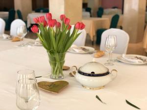 a table with a vase of red tulips and a tea pot at Hotel Isla Bella & Spa in Isla