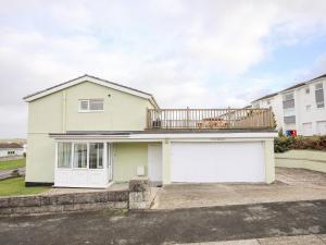 a house with a balcony and a garage at The Little Dolphins in Rhosneigr