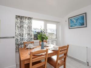 a dining room with a table and chairs and a window at The Little Dolphins in Rhosneigr