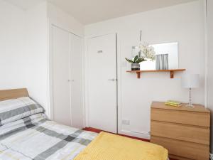 um quarto com uma cama e uma cómoda em madeira em The Little Dolphins em Rhosneigr