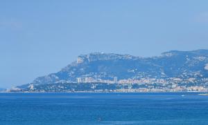 a large body of water with a mountain in the background at Sole Mare in Ventimiglia