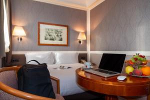 a hotel room with a desk with a laptop on it at Grand Hotel Ortigia in Siracusa