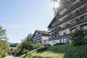 a building on a hill with the sun shining on it at Apartment Noemi in Bad Goisern