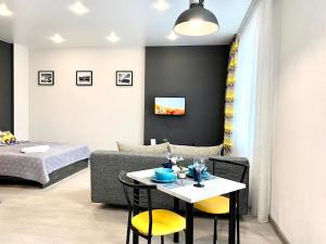 a living room with a bed and a table and chairs at Апартаменты Кирова 47 in Barnaul