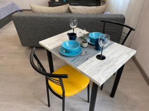 a table with plates and wine glasses on it at Апартаменты Кирова 47 in Barnaul