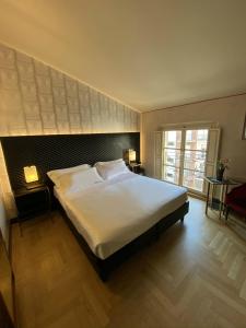 A bed or beds in a room at Hotel Verdi Boutique Hotel