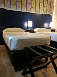 A bed or beds in a room at Hotel Verdi Boutique Hotel