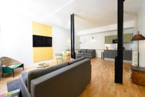 een woonkamer met een bank en een tafel bij Suites & Hôtel Helzear Montparnasse in Parijs