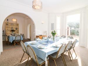 a dining room with a blue table and chairs at Babbacombe Hall in Torquay