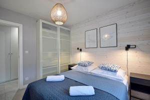 a bedroom with a blue bed with two pillows at e-apartament nad morzem Apartamentuj in Mielno