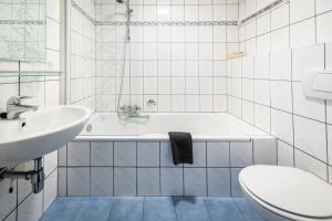 a bathroom with a tub and a sink and a toilet at De Drie Linden in Luyksgestel