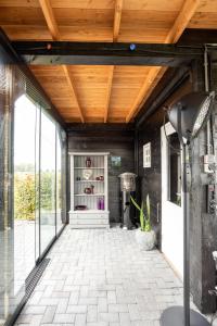 d'une terrasse avec un plafond en bois et des portes en verre. dans l'établissement Dinie's Bed en Brood, à 's-Heerenbroek