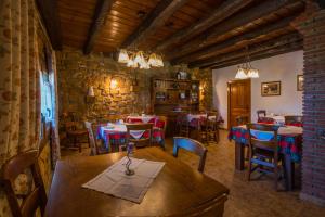 um restaurante com mesas e cadeiras e uma parede de pedra em CASA RURAL ETXANO em Amorebieta-Echano
