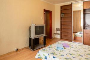 sala de estar con TV y cama en Квартира по адресу Приозерная 8 Б Оболонь, en Kiev