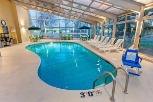 a large swimming pool in a building with chairs at La Quinta by Wyndham Stevens Point in Stevens Point