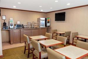 a restaurant with tables and chairs and a kitchen at La Quinta by Wyndham Stevens Point in Stevens Point