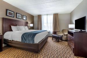 a hotel room with a bed and a flat screen tv at Comfort Inn & Suites Glen Mills - Concordville in Glen Mills