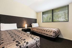 a bedroom with two beds and a window at Quality Suites Amore in Christchurch