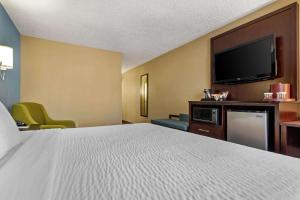 a hotel room with a bed and a flat screen tv at Clarion Hotel Conference Center - North in Lexington