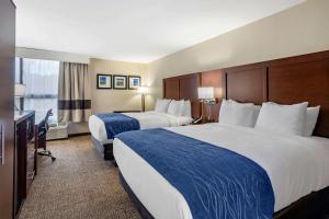 a hotel room with two beds and a desk at Comfort Inn Nashville - Opryland Area in Nashville