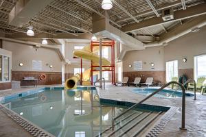 a swimming pool with a slide in a building at Quality Inn & Suites in Rimbey