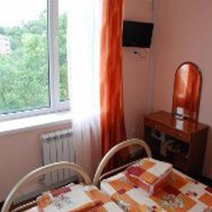 a room with a table and two chairs and a window at Guest House Villa Nadezhda in Lazarevskoye