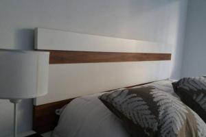 - une chambre avec un lit et une tête de lit en bois dans l'établissement Amplio, céntrico, luminoso, à Rosario