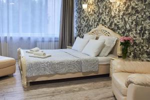 a bedroom with a bed and a couch at Hotel Royal (Отель Роял) in Poltava